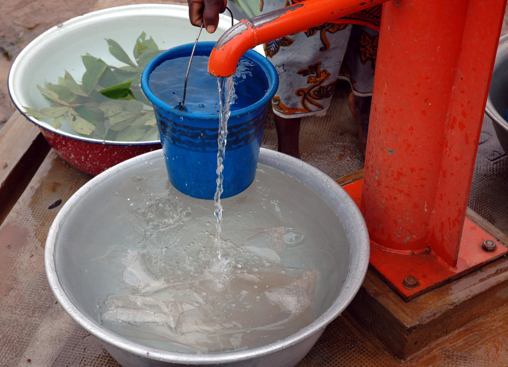 Water pump being used to fill bowls of water.