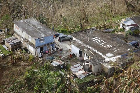 Aerial photo of a home in Puerto Rico with "Help" and a frowny face written on the roof.