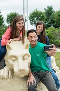 Three students posing for a picture at the Nittany Lion Shrine.
