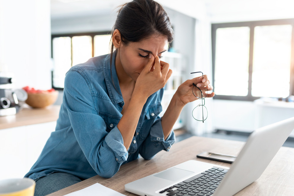 Woman experiencing work burnout in front of her laptop