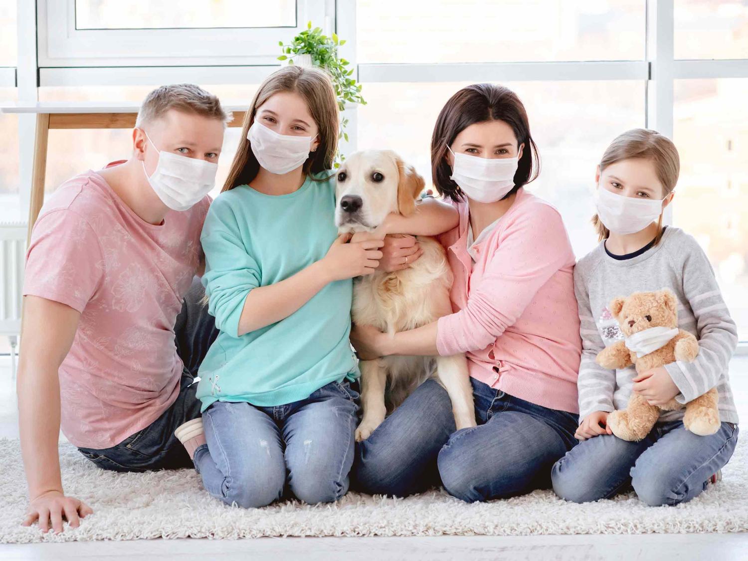 Young children wearing masks with a dog and cat.