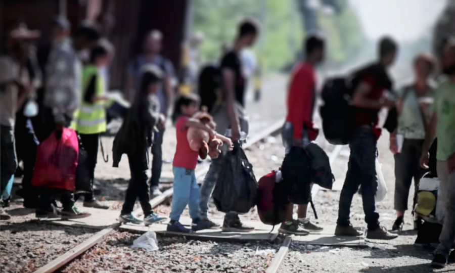 Migrants crossing railroad tracks