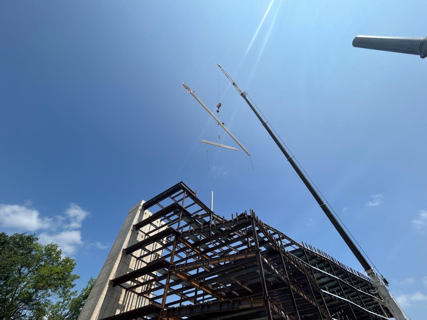 Final steel beam being placed at the top of the new Susan Welch Liberal Arts Building