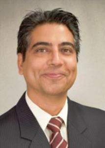 Headshot of Yubraj Acharya with dark hair wearing a suit and red tie.