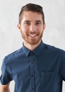 Headshot of Andrew Zeveney, short brown hair, beard, blue collared shirt.