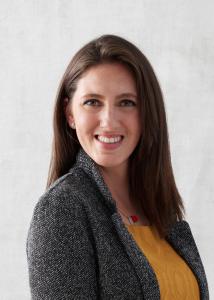 Ashley Stauffer Headshot medium brown hair, blazer, yellow shirt.