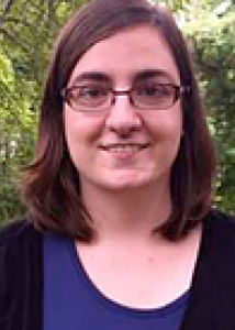 Headshot of Lawrie Green, shoulder length medium brown hair, wire frame glasses.