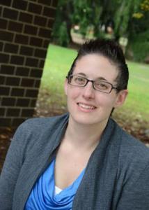 Headshot of Samantha Tornello outside with short, brown hair and glasses wearing a blue top with a grey jacket. 