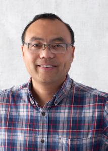 Headshot of Steven Xing, plaid button down shirt, short brown hair, and wire framed glasses.