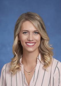 Woods with long blonde hair and pink stripe shirt