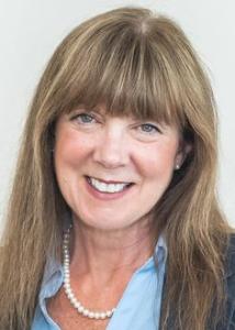 Headshot of Brenda Russell, a white women with long, dark blonde hair with bangs, blue eyes, and blue blazer.