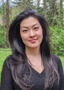 Headshot of Holly Nguyen, an Asian woman with long, dark hair wearing a black long-sleeved shirt.