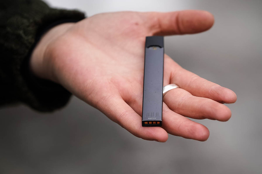 Man holding a JUUL