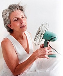 Photo of an older woman holding a fan.