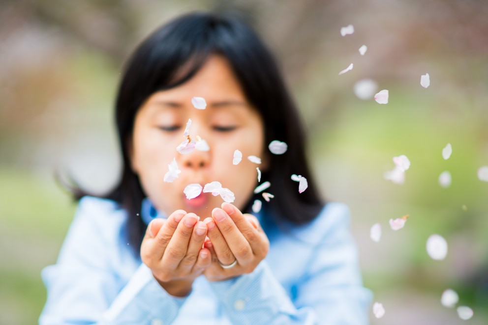 Girl blowing flower petals