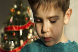 Photo of a child in front of a Christmas tree.