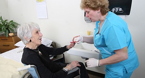 Photo of a dental hygienist and an older female patient.