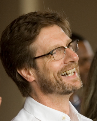 Headshot of Richard Wright with brown hair, beard, glasses, and white shirt.