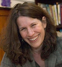 Headshot of Sharon Sassler with long brown hair, black shirt, and gray jacket.