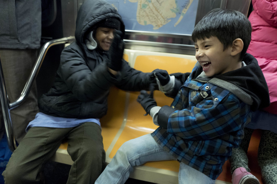 Schoolchildren play on a New York subway.