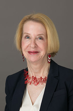 Headshot of Janice with blonde hair, white blouse, and black jacket.