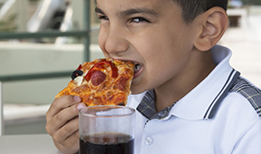 Latino child eating pizza