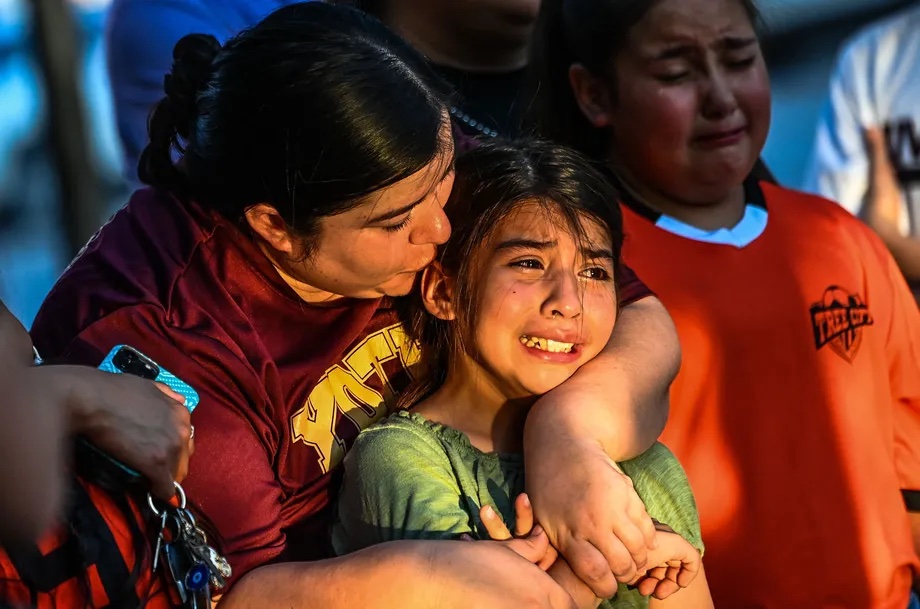 Gabriella Uriegas, a soccer teammate of Tess Mata, who died in the mass shooting at Robb Elementary School, cries as her mother tries to comfort her as they visit a makeshift memorial. 