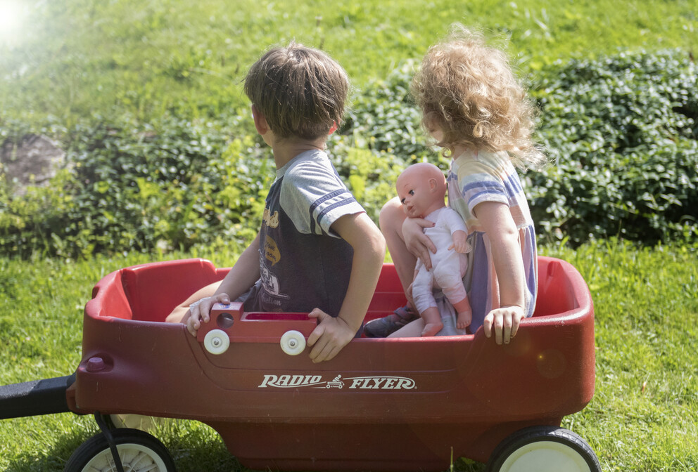 Two children in a red wagon