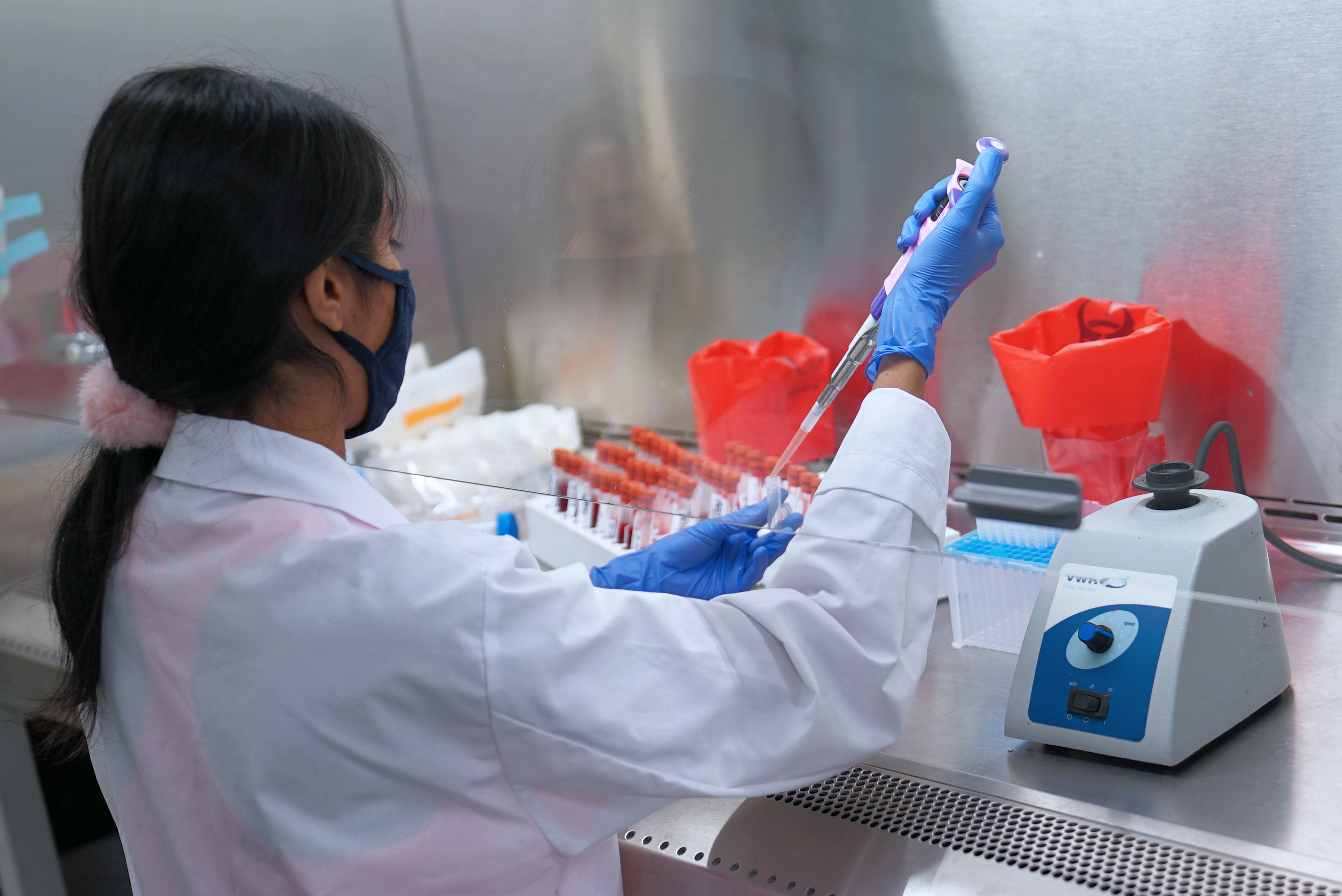 Research assistant preparing blood samples in a lab.