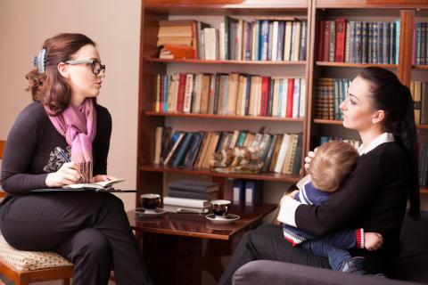 A therapist talking with a mother and her young child.