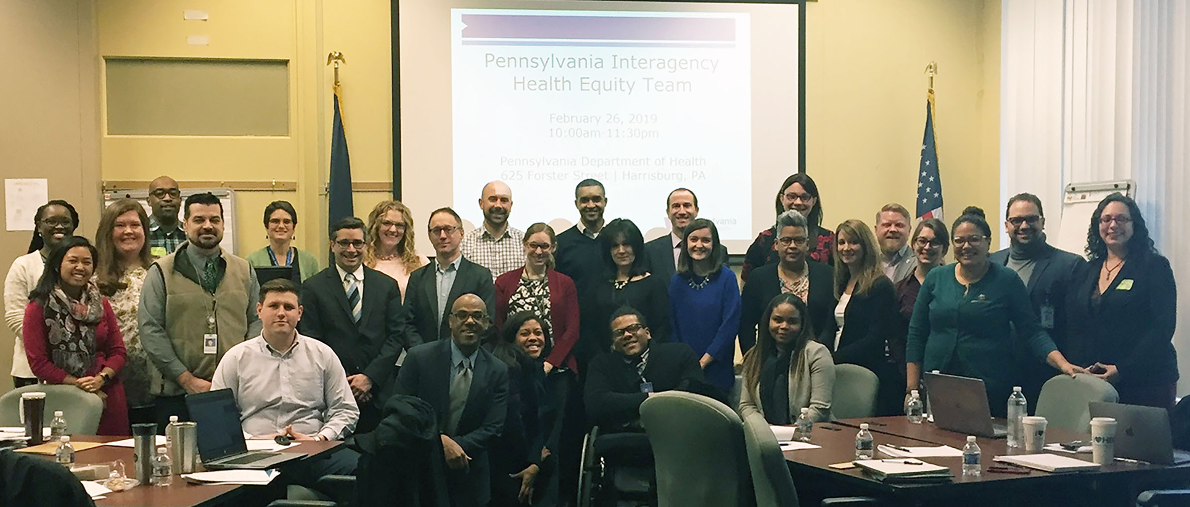 Photo of the large group of people on the Health Equity Team standing at the front of the room during a conference.