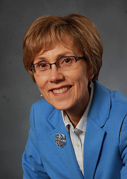 Penny Kris-Etherton with short brown hair, glasses, white blouse, and blue jacket.