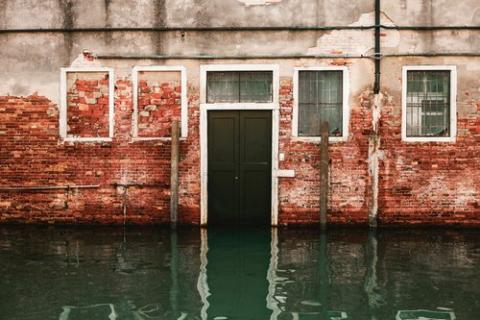 Photo of a brick building with a flooded street.