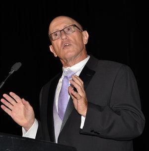 Photo of Ronald Wasserstein with glasses, purple tie, white shirt, gray vest, and black jacket.