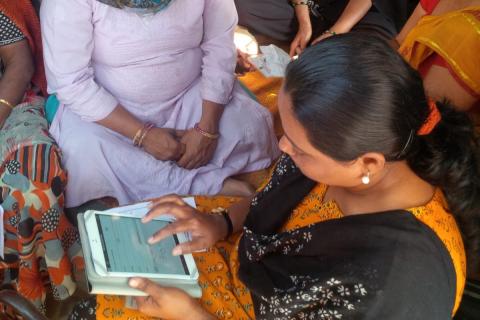 Hindu women sitting together with an iPad.