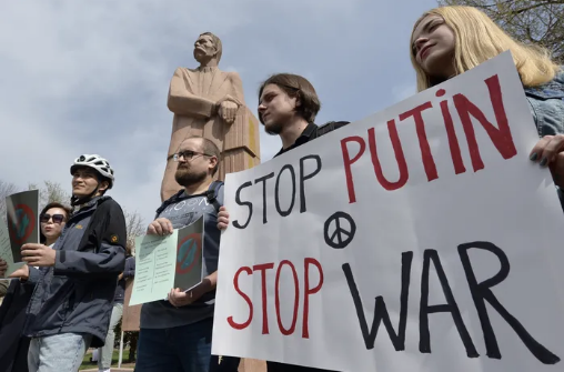 Demonstrators hold an anti-war poster during an anti-war and anti- Putin rally in Gorky Park in Bishkek, Kyrgyzstan