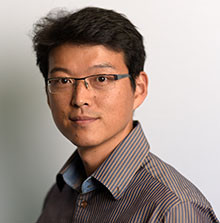 Headshot of Yongsoo Kim with black hair, glasses, and brown and gray striped shirt.