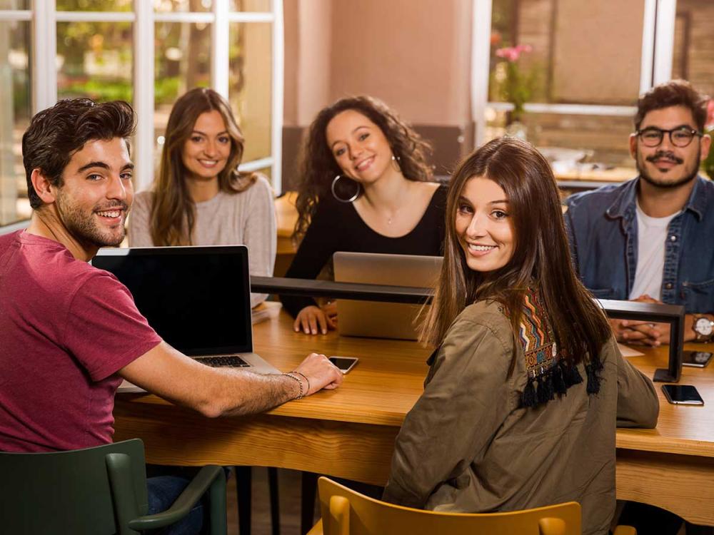 Group of Latino college students on laptops.