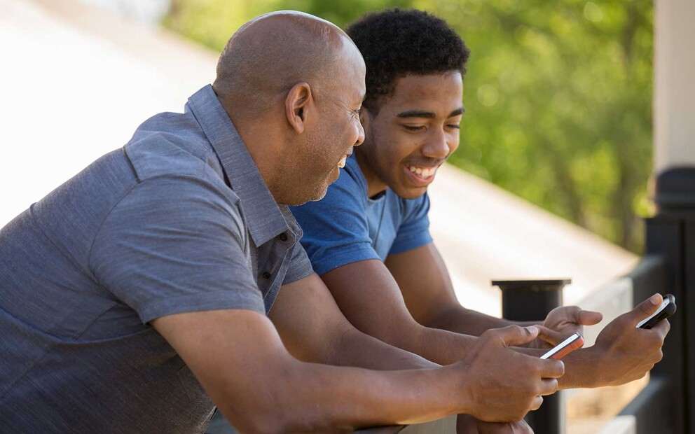 African American father and son with iPhones.
