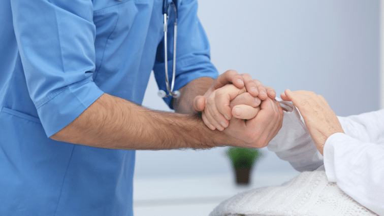 Doctor holding hand of patient