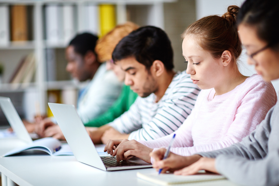 Students in classroom on laptops.