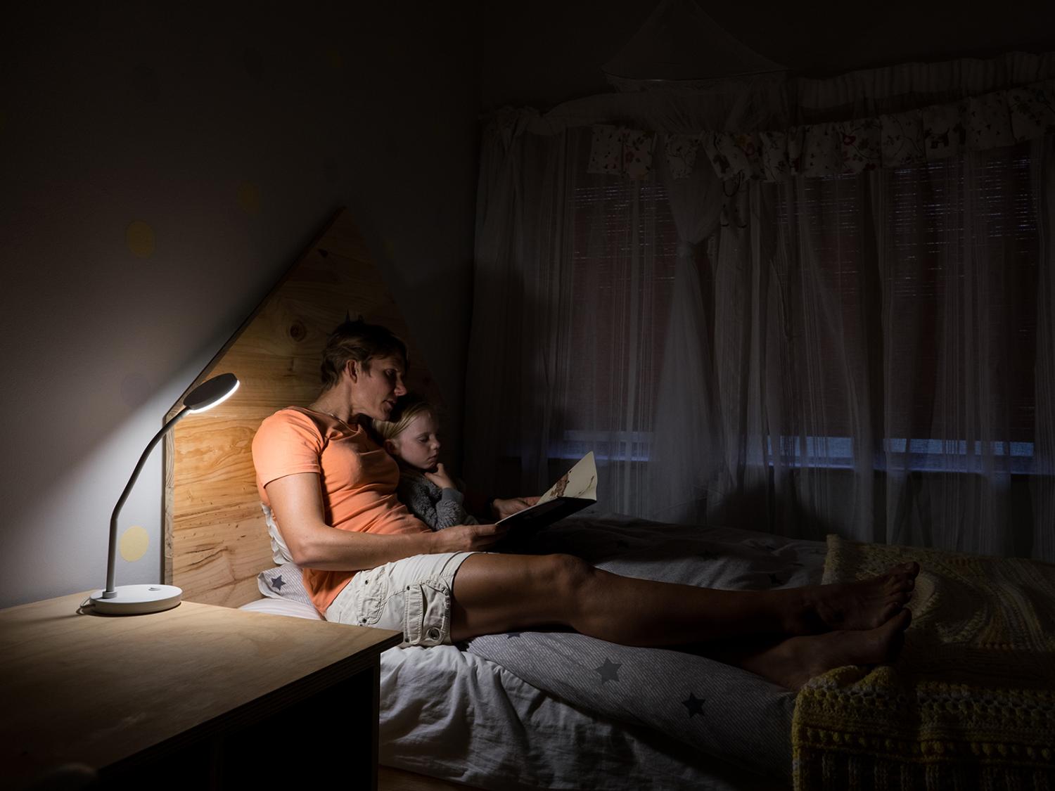 Mother and young child reading in bed
