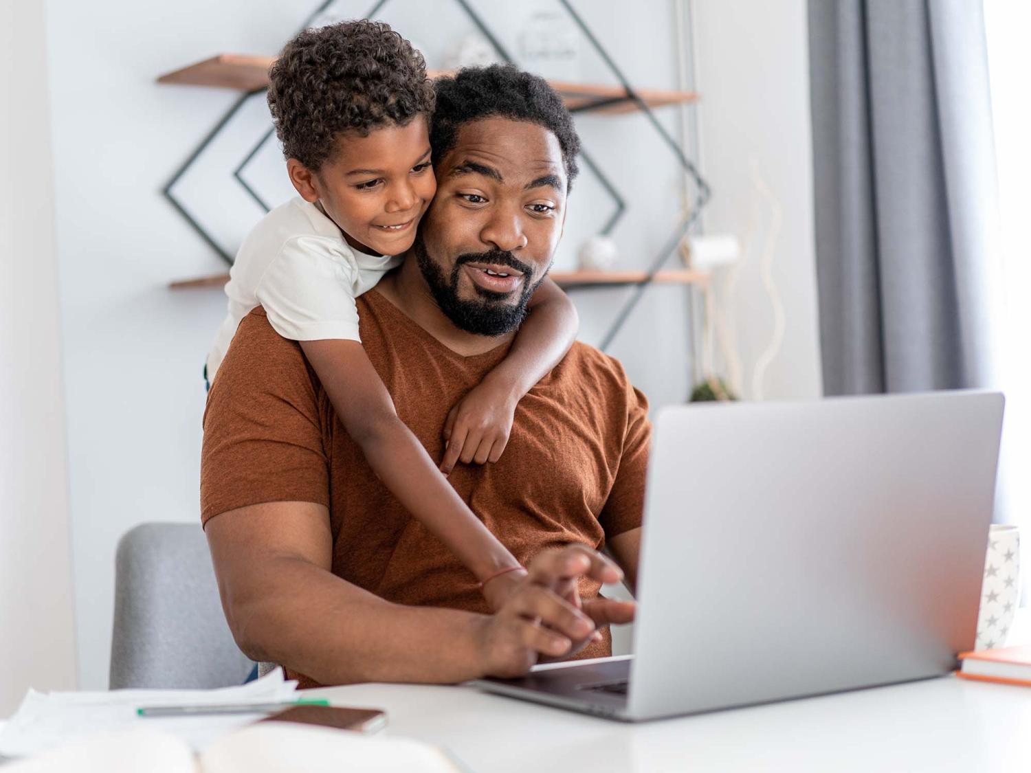 African American father with son working on laptop computer