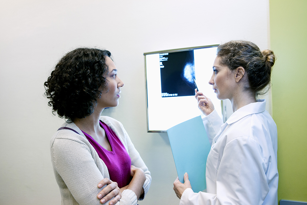 Photo of a doctor going over mammogram images with a patient.