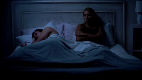 Sleeping couple, woman awake.