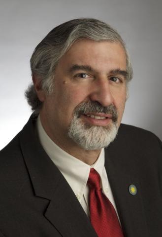 Richard Kurin, Distinguished Scholar & Ambassador at Large, Smithsonian Institution head shot in black jacket, white shirt, and red tie with gray hair and beard