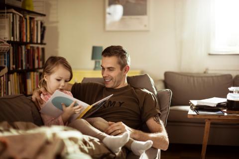 Military father reading to young daughter.
