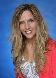 Headshot of Danielle Downs with long blonde hair, white and gray shirt, and pink jacket.