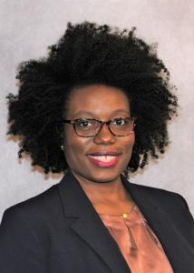Headshot of Cleothia Franzier, a black woman with a dark afro-style hair and glasses wearing a black suit jacket and golden colored shirt.