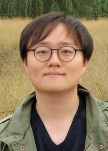 Headshot of Jungmin Lee with short dark hair, glasses, black shirt, and green jacket.